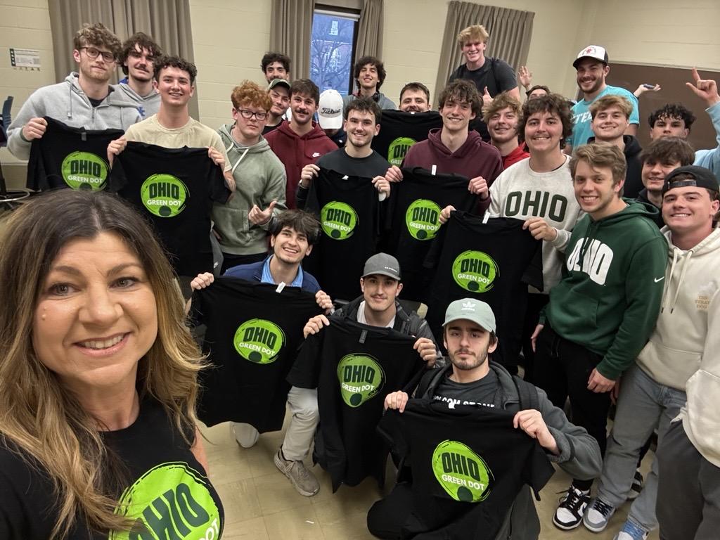 attendees holding green dot t shirts